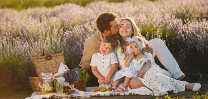 A joyful family enjoying a picnic together in a scenic lavender field during summer.