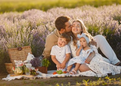 A joyful family enjoying a picnic together in a scenic lavender field during summer.